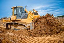 Bulldozer excavating and moving dirt