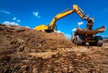 Excavator clearing land
